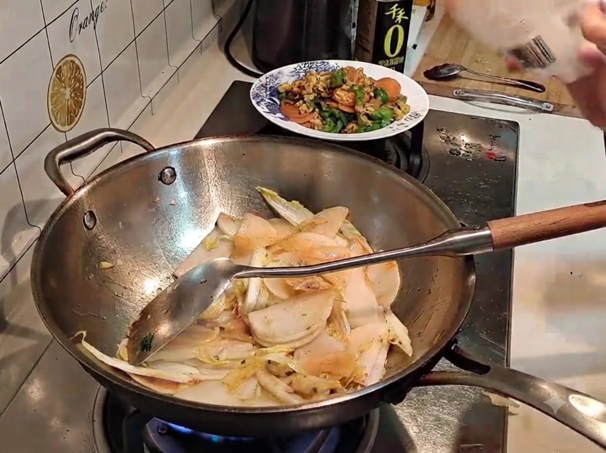 Sal siendo espolvoreada desde un paquete en un wok que contiene verduras en rodajas.