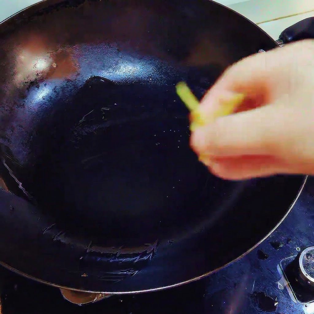 Trozos de jengibre y ajo cayendo en un wok que contiene manteca derretida sobre el fuego.