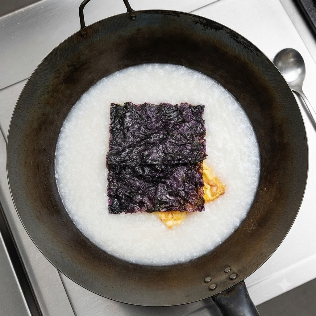 Algas secas flotando en la parte superior de la sopa blanca en el wok.