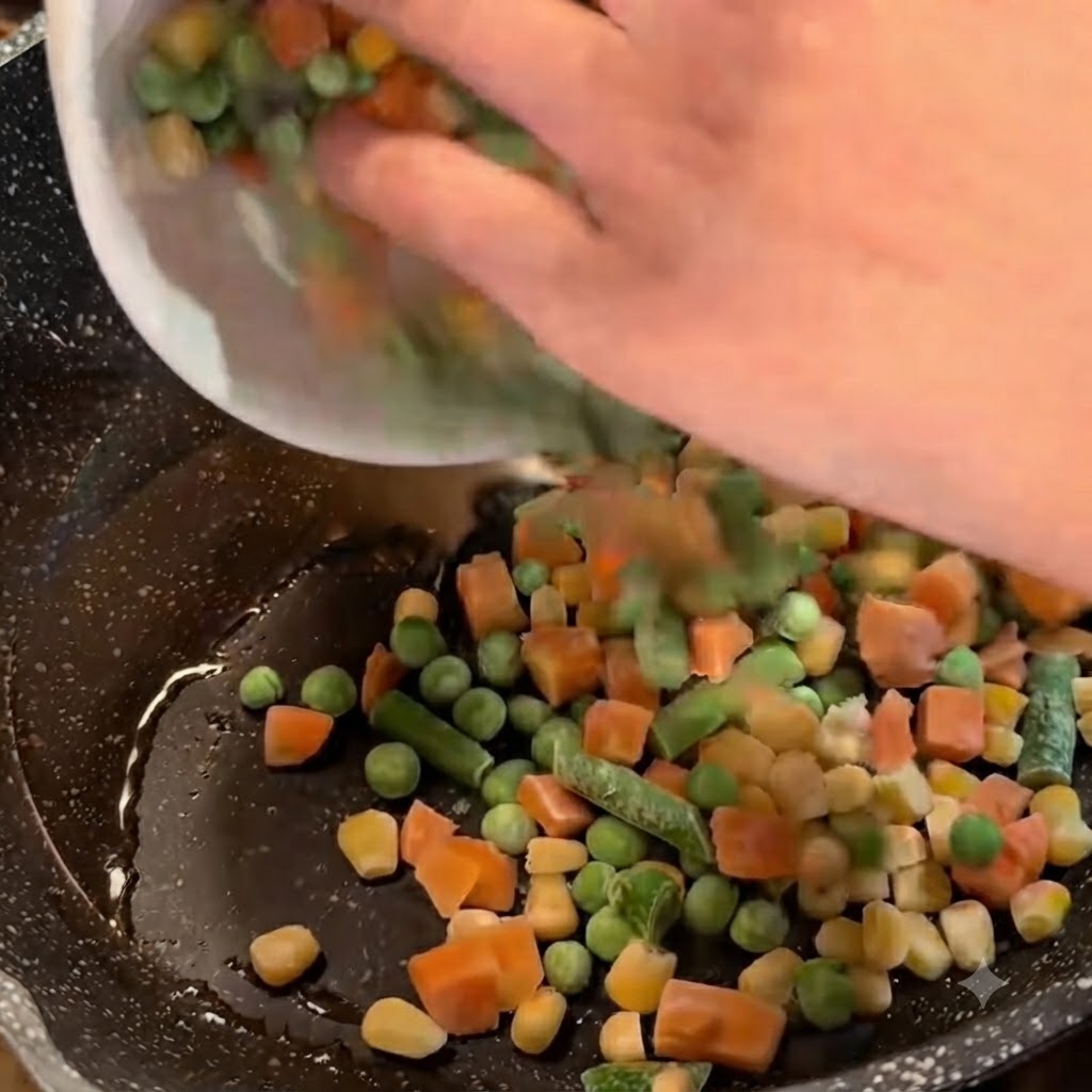 Verduras mixtas congeladas siendo vertidas desde un bol blanco en una sartén con aceite y cebolletas.