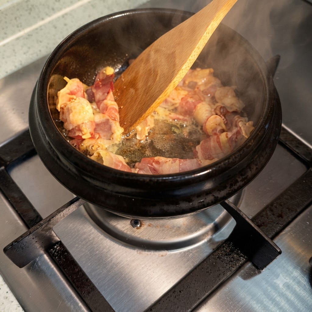 Salsa de soja vertiéndose sobre las tiras de carne que se cocinan en la olla caliente, generando vapor.
