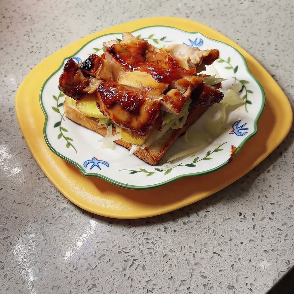 Un sándwich de pollo teriyaki y piña terminado sobre una bandeja amarilla, listo para la salsa y el servicio.