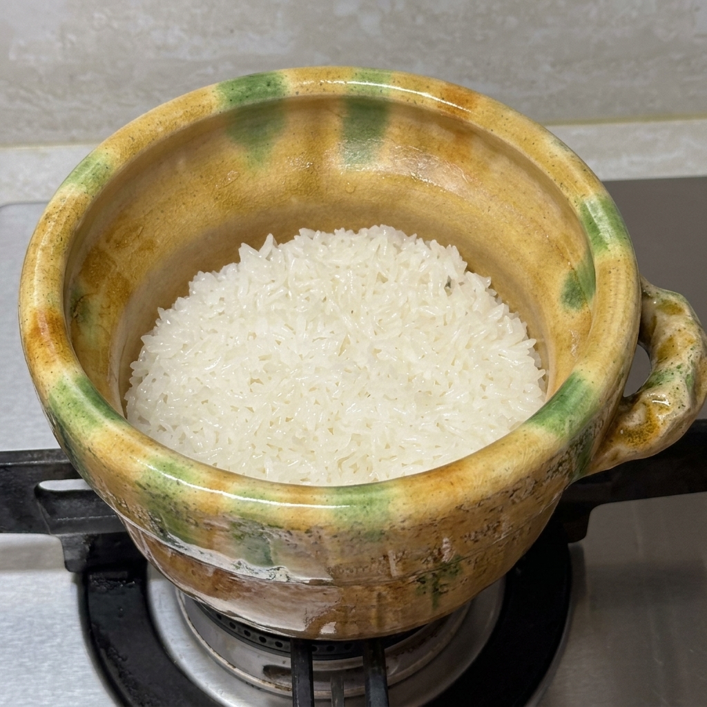 Filete de salmón sellado siendo colocado en la cazuela sobre el arroz blanco en cocción.