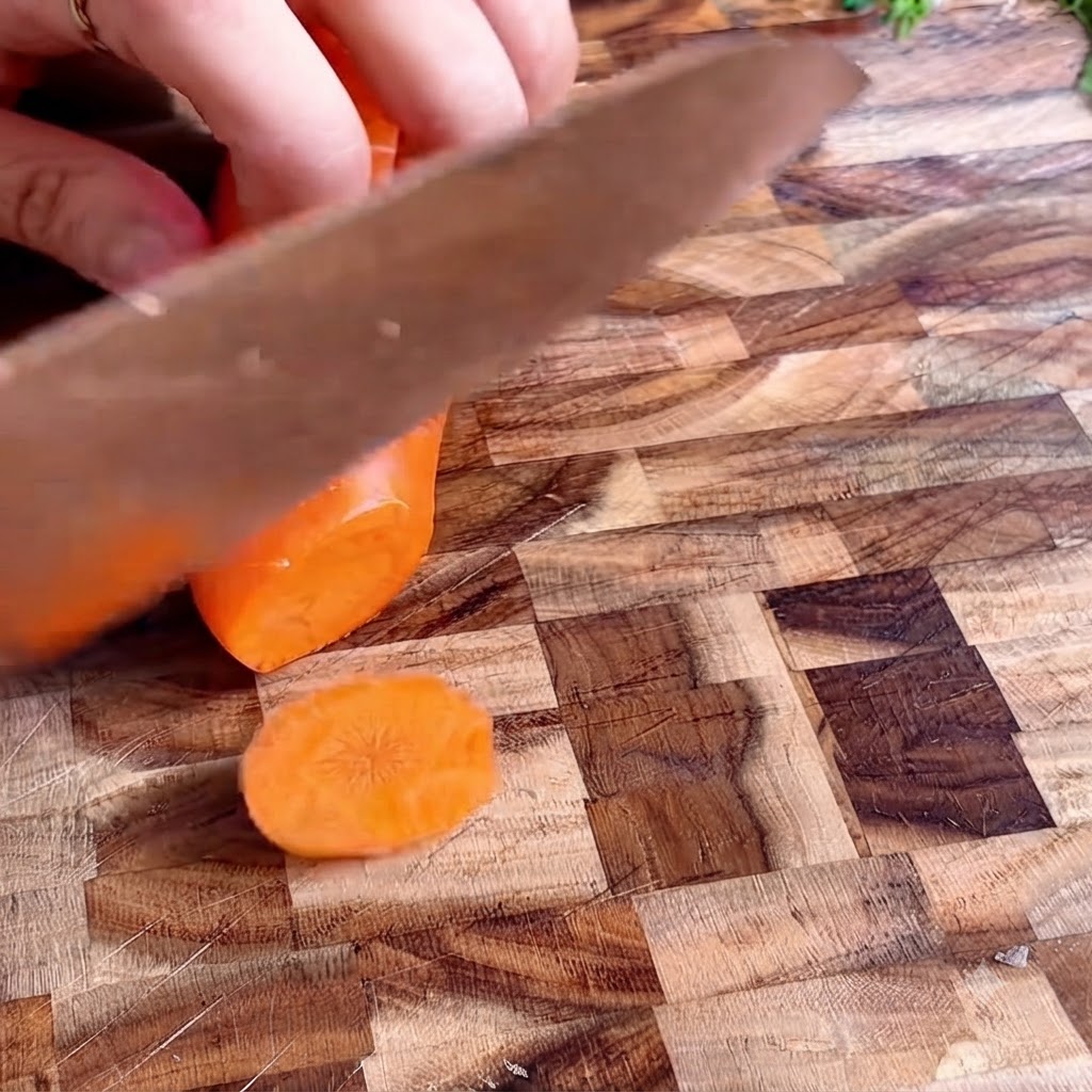 Rodajas de zanahoria ordenadas en una tabla de cortar de madera.