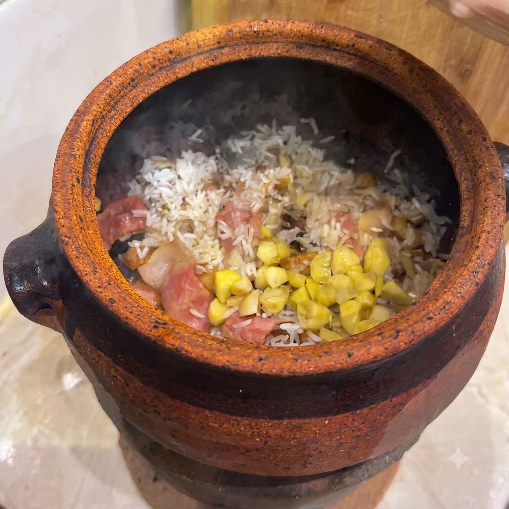 Nueces de ginkgo y trozos de castaña amarilla esparcidos sobre una base de arroz mezclado y tocino dentro de una cazuela de barro.