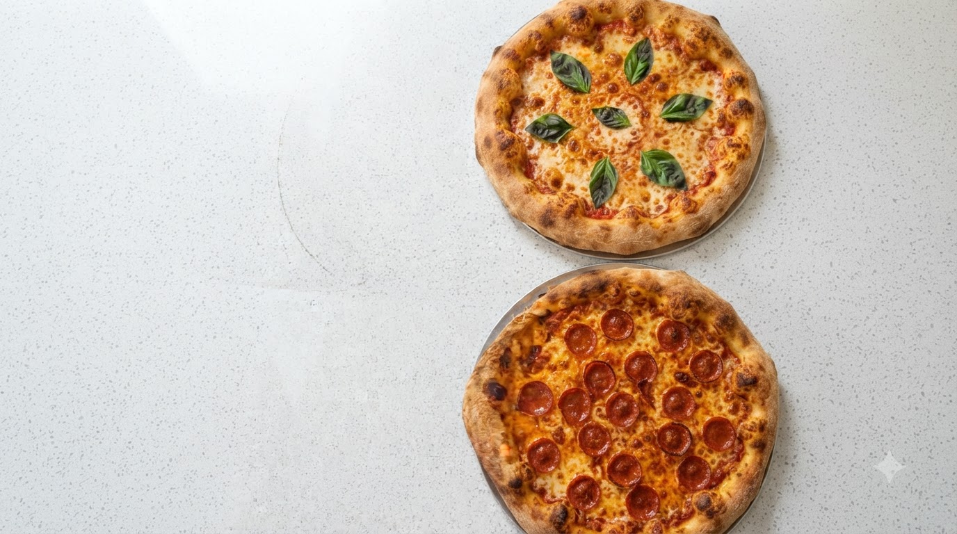 Dos pizzas italianas clásicas recién horneadas presentadas una al lado de la otra: una Margherita dorada con albahaca fresca y una pizza de salami con queso fundido.