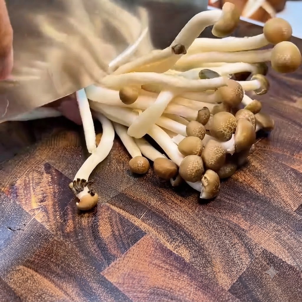 Setas shimeji siendo recortadas en el grupo de la raíz con un cuchillo en una tabla de madera.