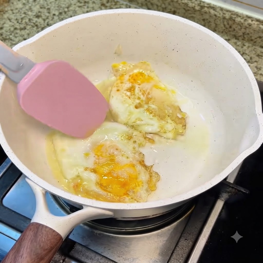Camarones marinados cocinándose en la olla blanca junto con los huevos fritos a fuego lento.