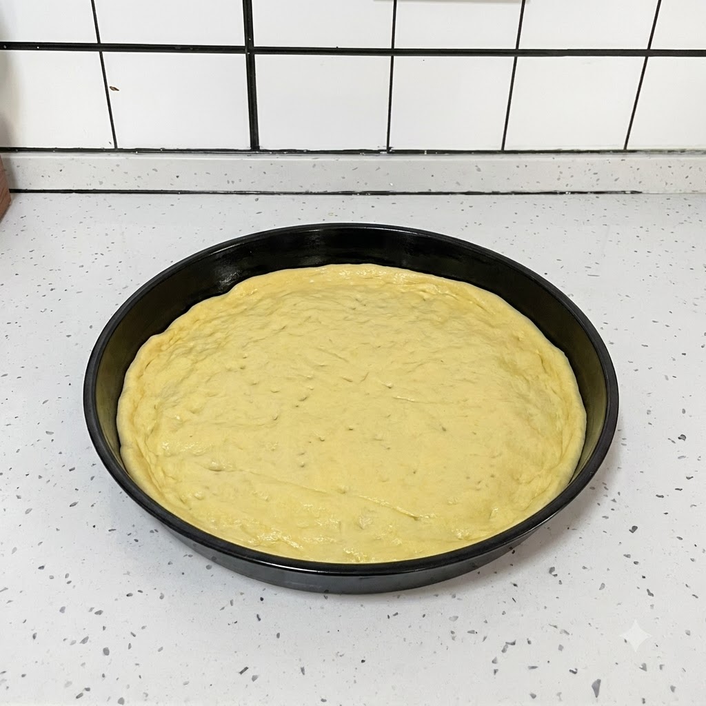 Una herramienta de cocina negra utilizada para hacer pequeños agujeros de forma uniforme en una masa de pizza redonda y aplanada dentro de un molde negro.