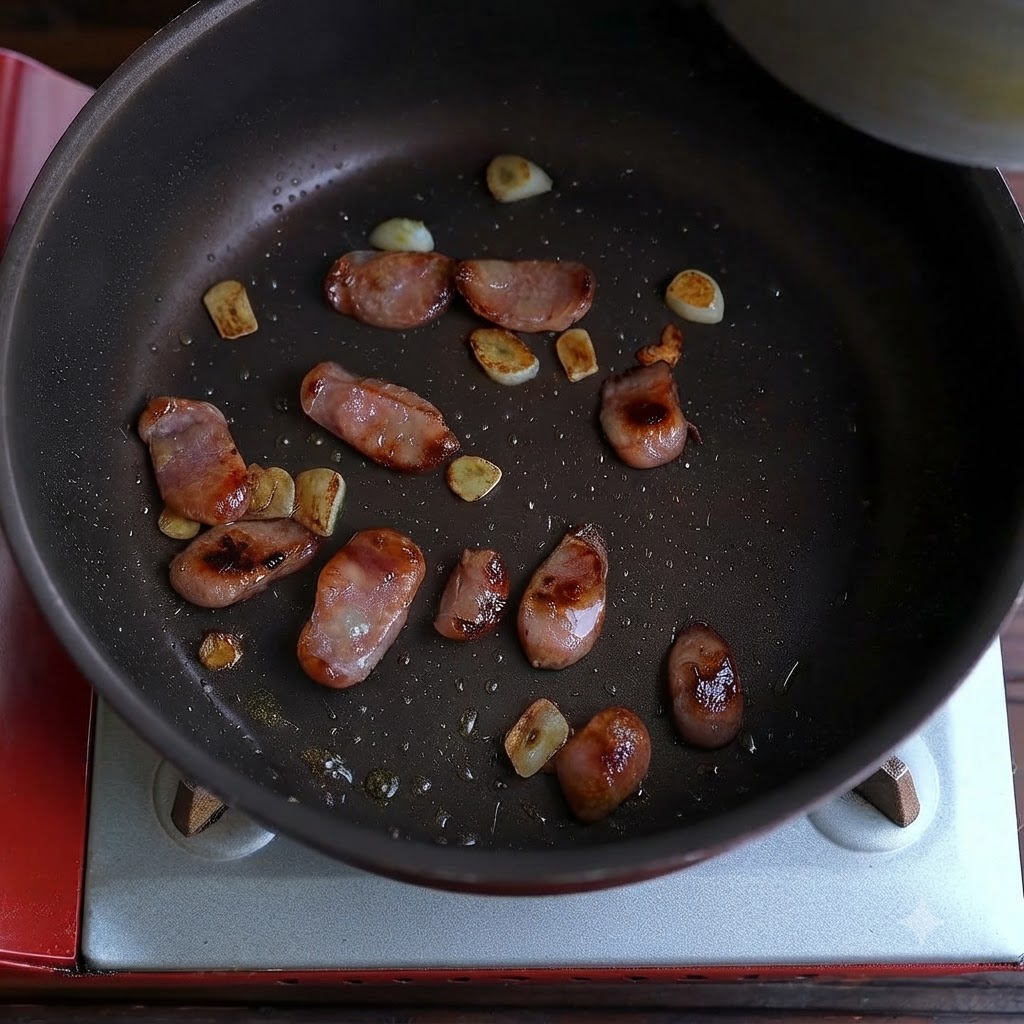 Salchicha cocida y trozos de ajo frito dispersos por el fondo de una sartén.