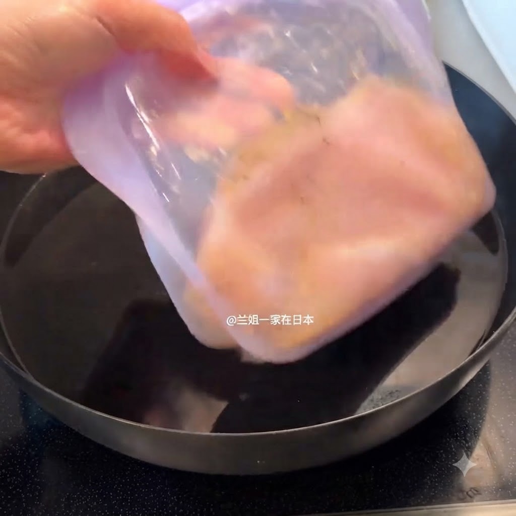 Un recipiente morado sellado con pollo marinado siendo colocado dentro de una olla llena de agua.