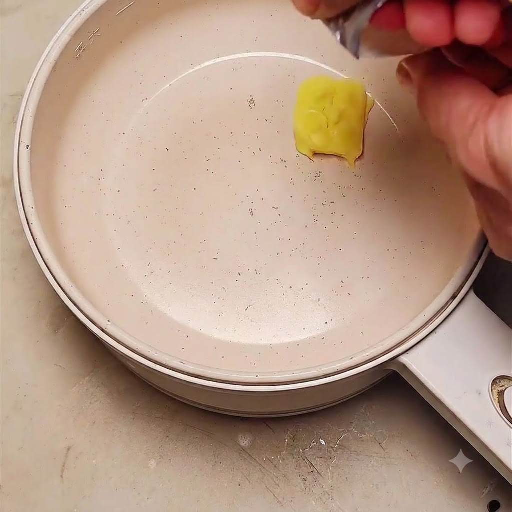 Una porción de mantequilla derritiéndose en una sartén con cebollas rojas en rodajas que se están añadiendo.