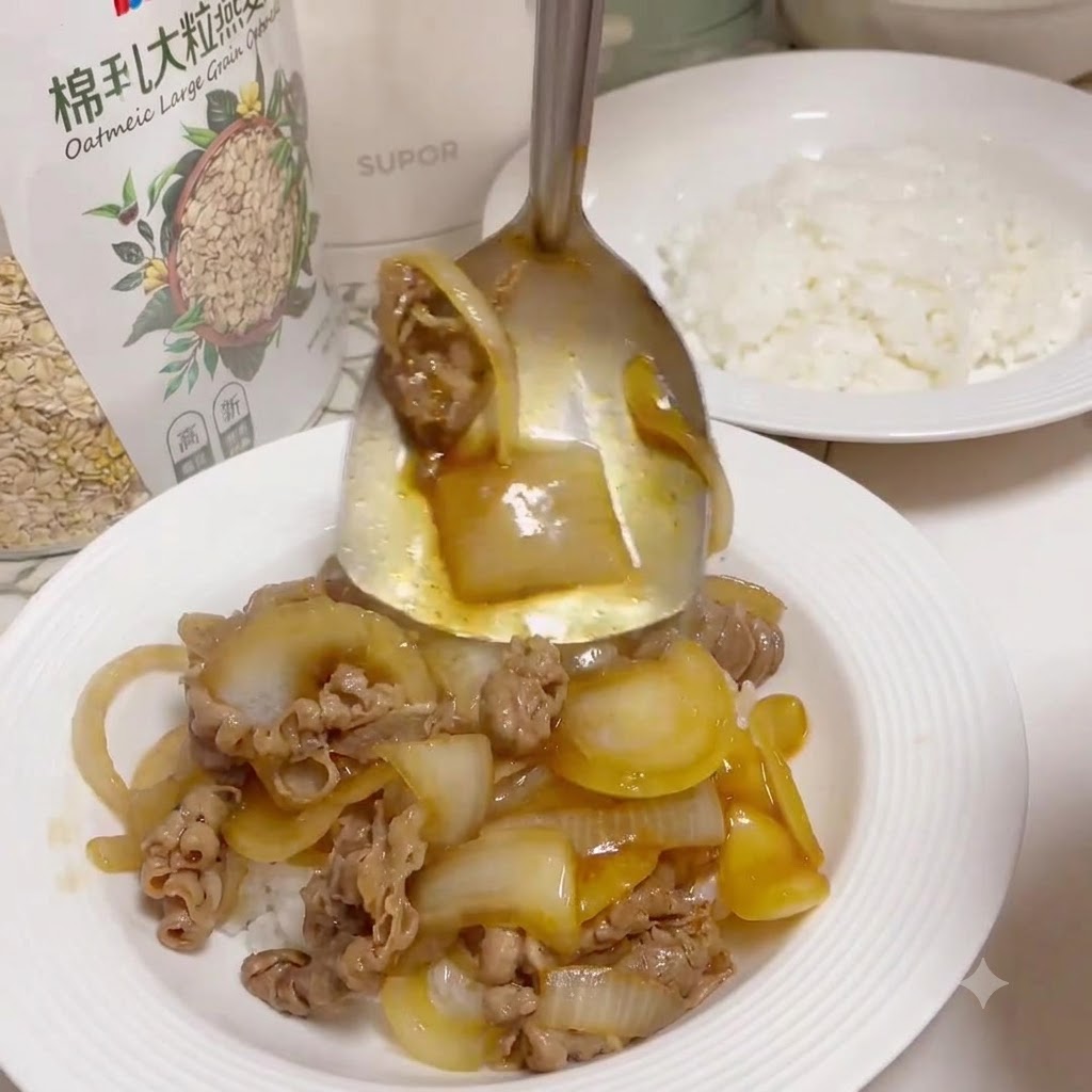 Una cuchara de servir de metal recogiendo ternera cocida y cebollas glaseadas de una sartén para salsear sobre un plato blanco lleno de arroz blanco cocido.
