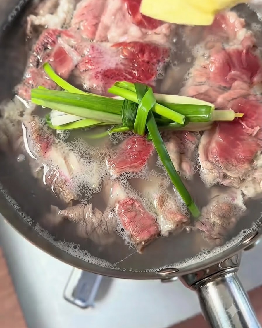 Nudos de cebollino y trozos de jengibre flotando en una olla con ternera hirviendo.