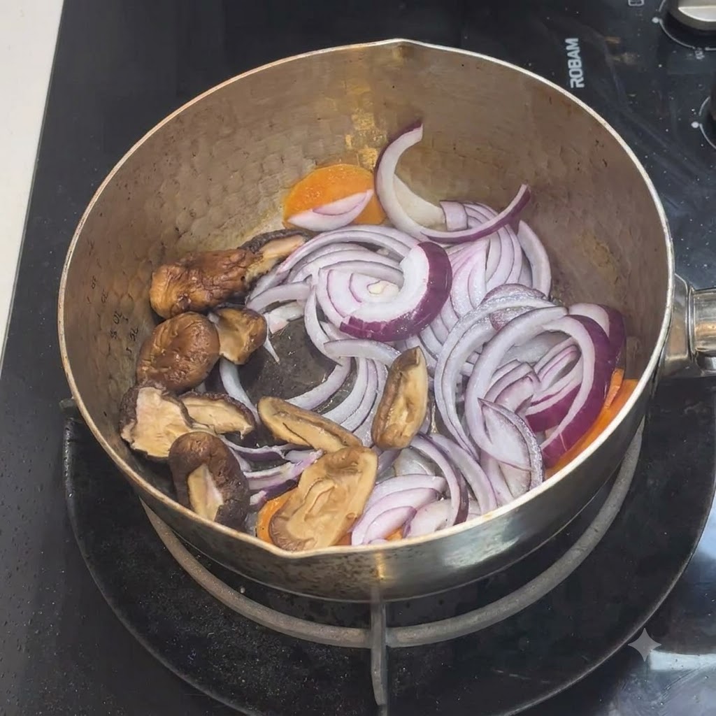 Champiñones shiitake en rodajas colocados dentro de la olla con la mezcla existente de cebollas y zanahorias.