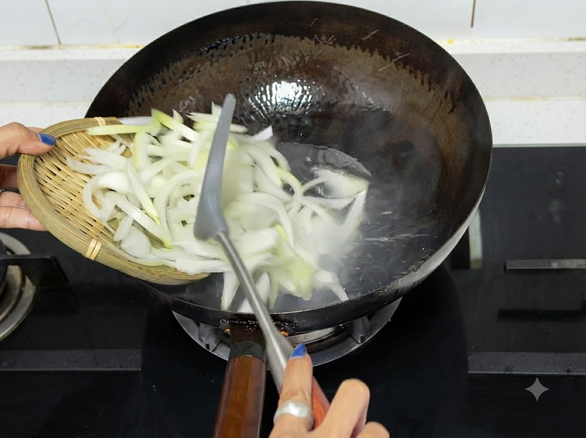 Cebollas cortadas vaciándose desde una bandeja de madera hacia un wok caliente sobre la estufa.