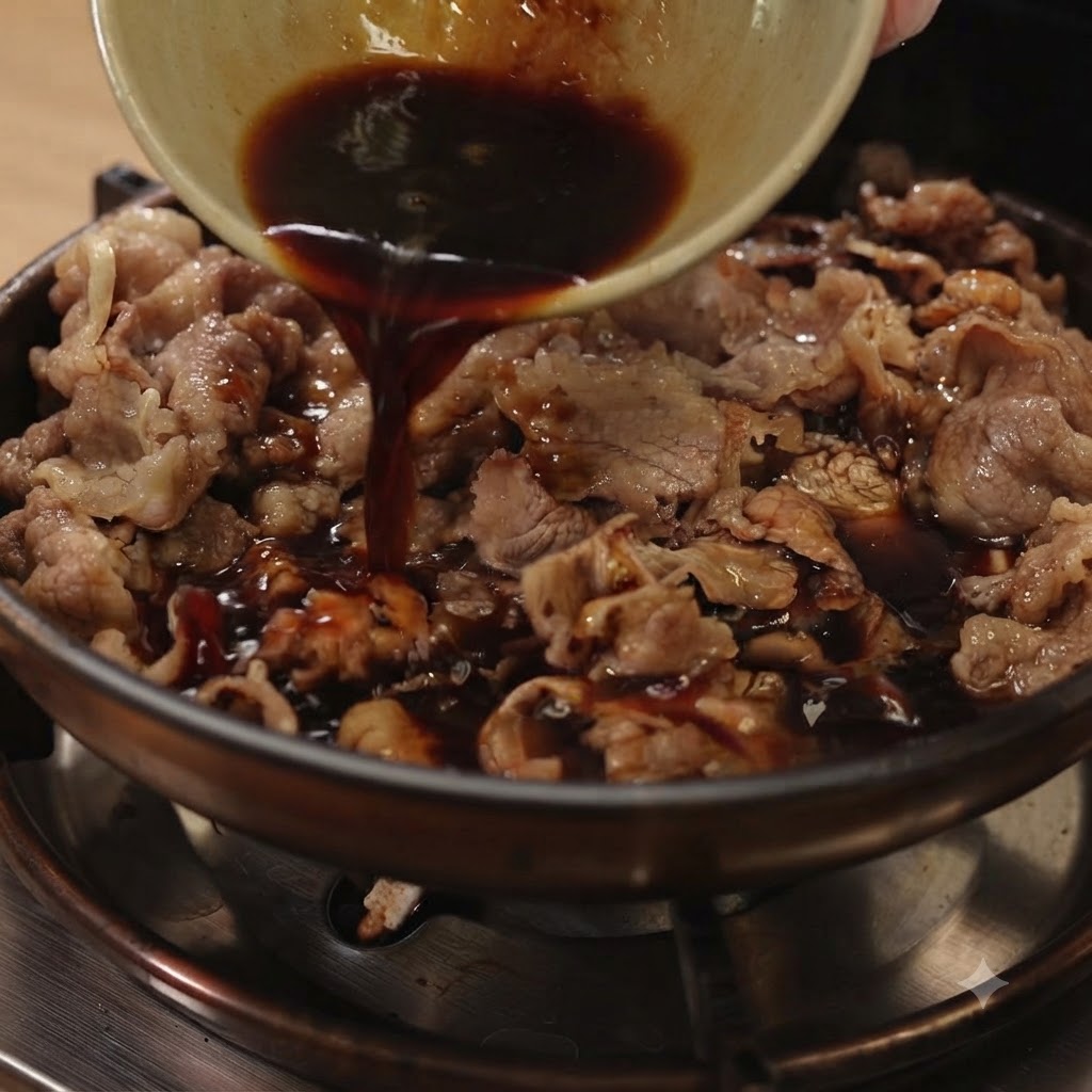 Salsa teriyaki oscura siendo vertida desde un pequeño cuenco en una sartén llena de carne en rodajas y cebollas moradas.