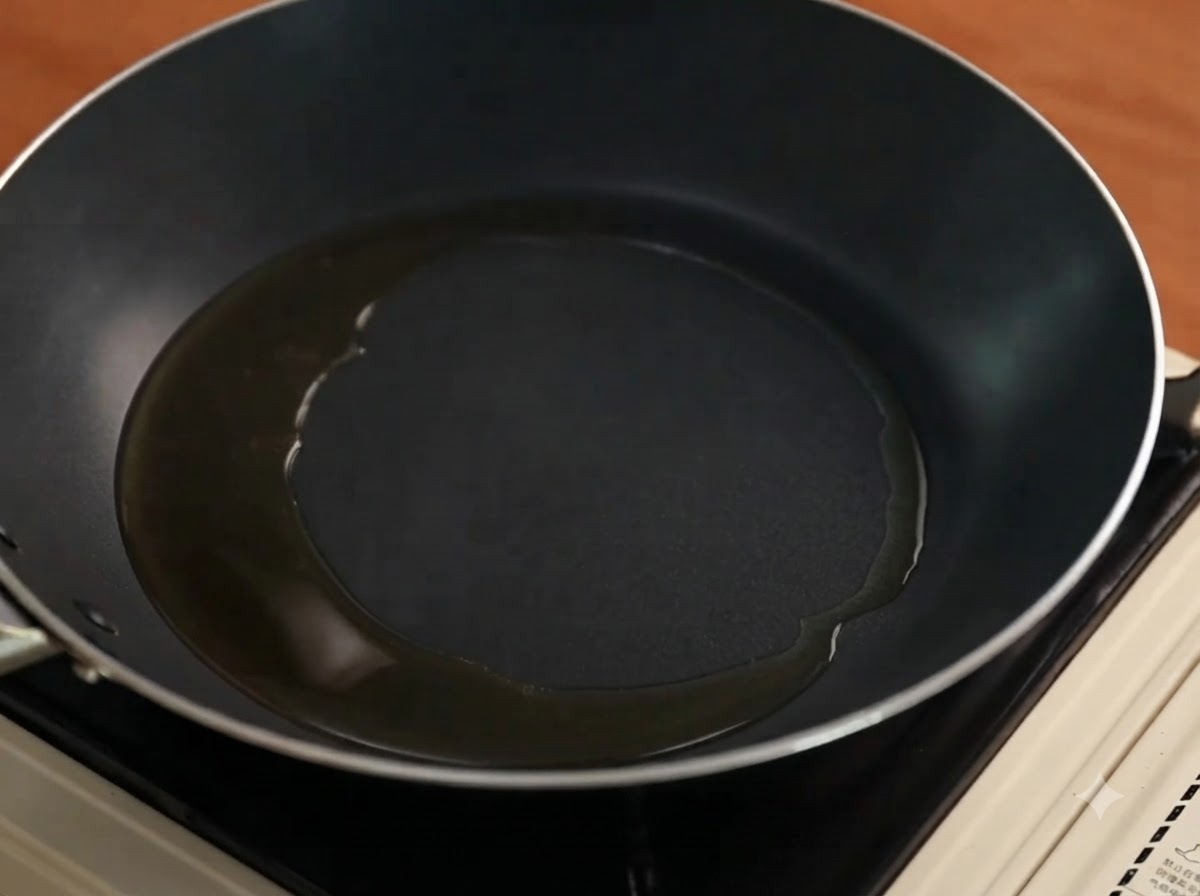Cebollas moradas cortadas cocinándose y chisporroteando en una sartén con aceite.