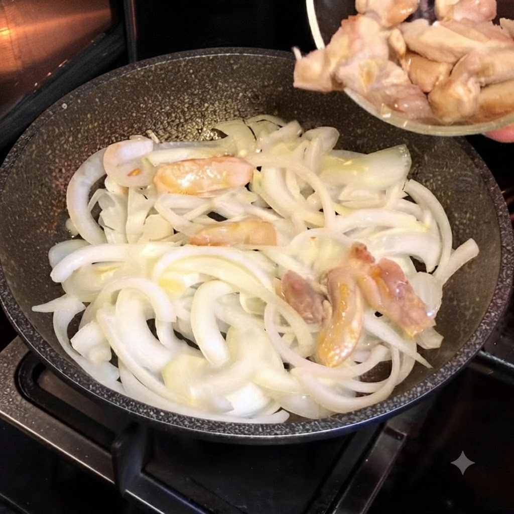 Trozos de pollo parcialmente cocinados siendo vertidos desde un pequeño tazón de vidrio en una sartén caliente llena de cebollas blancas cortadas.