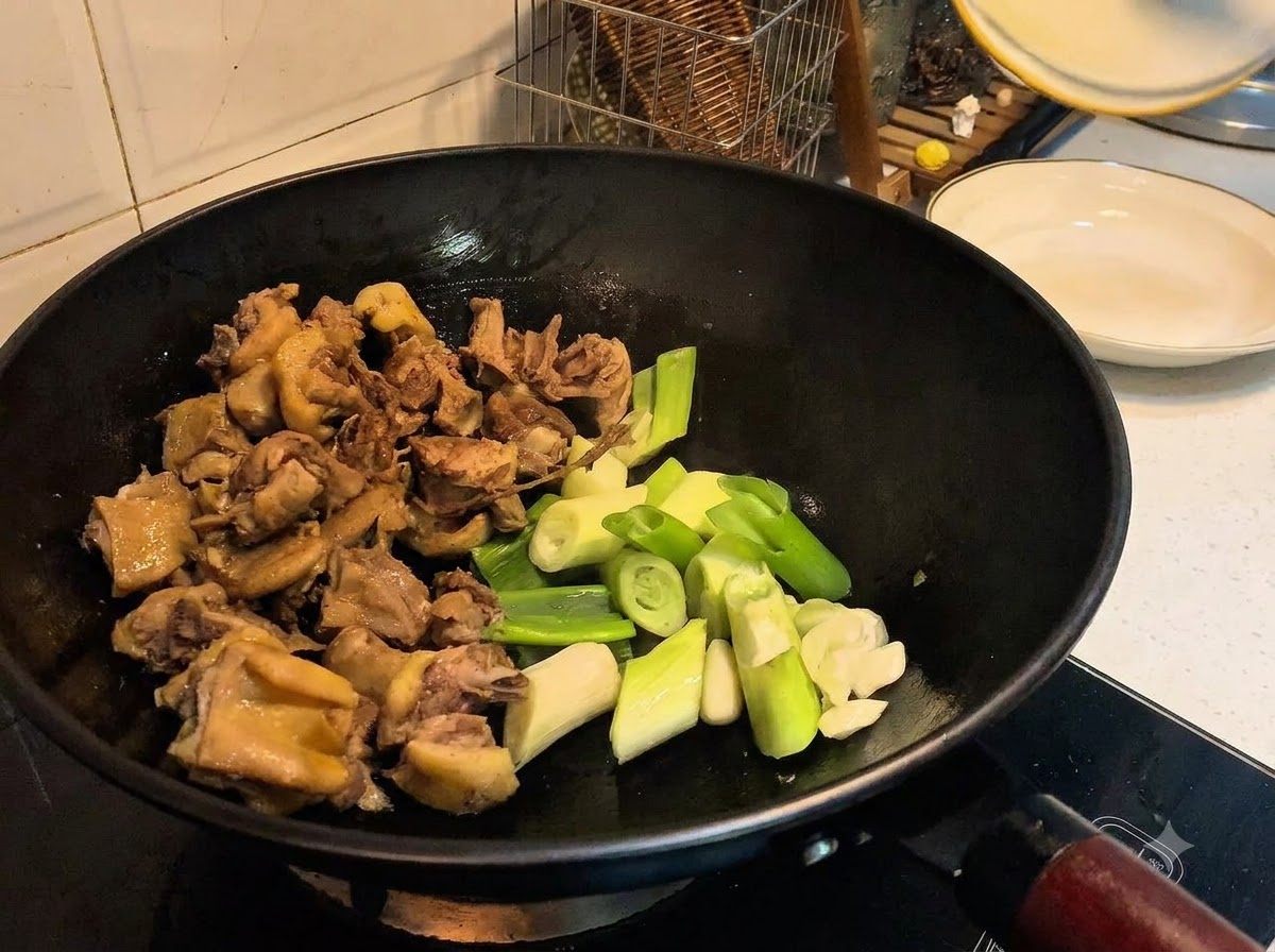 Cebollines, ajo, jengibre y especias añadidos al wok junto con el pato.
