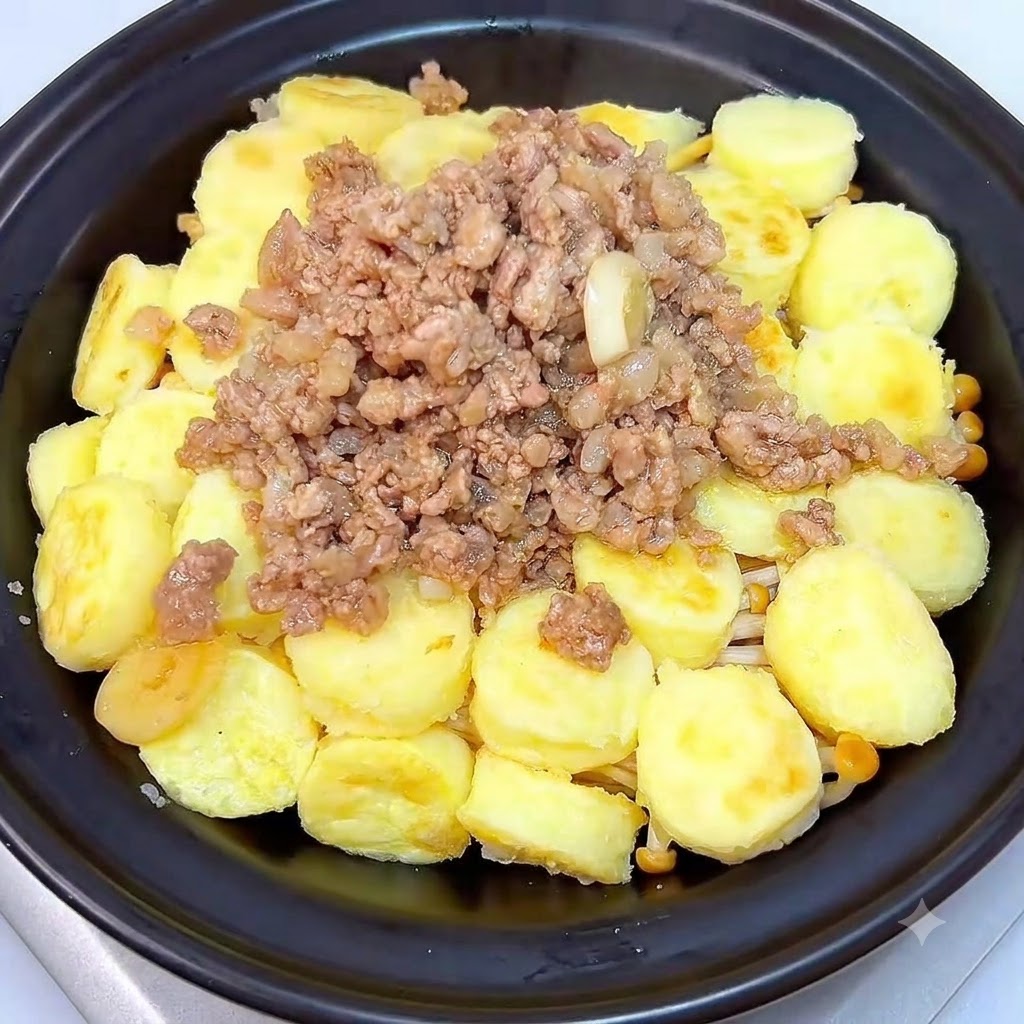 Una olla de barro negra cubierta con su tapa a juego sobre una estufa.