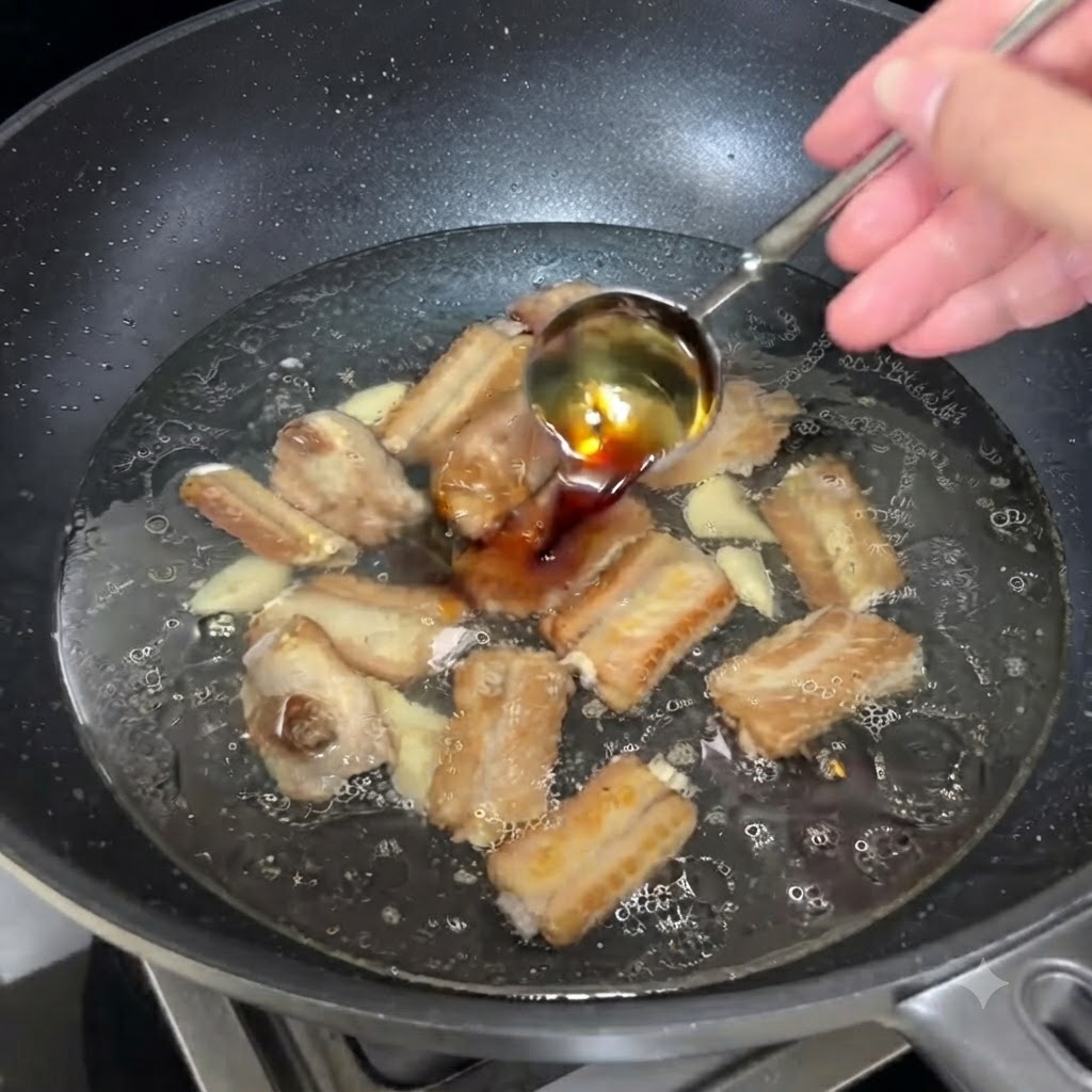 Una cucharada de salsa de soja clara siendo vertida en el caldo burbujeante con costillas.