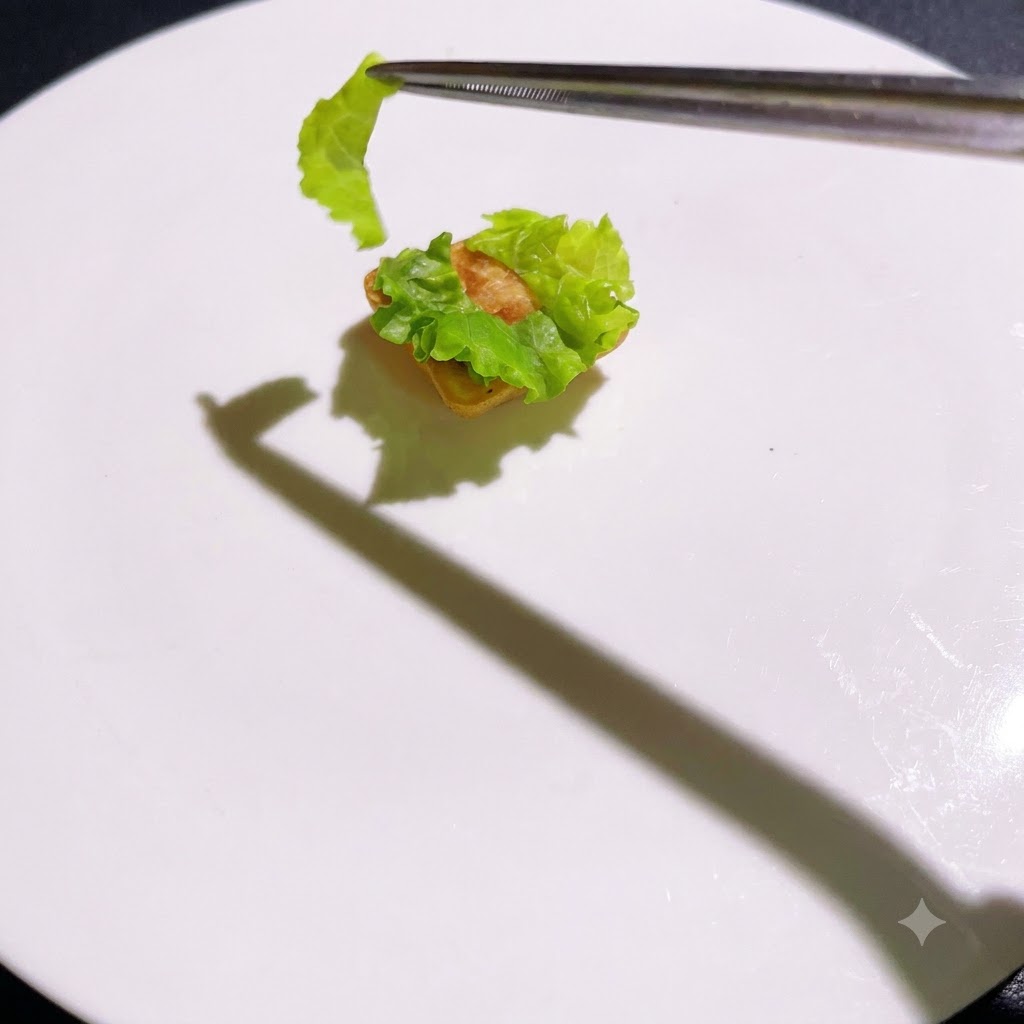 Capas cocinadas siendo apiladas secuencialmente sobre la base de lechuga con pinzas.