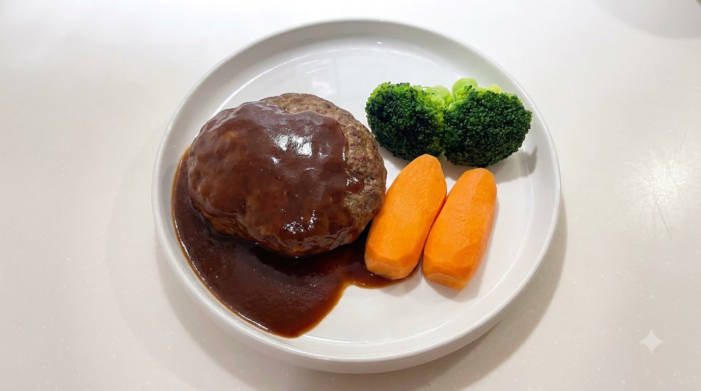 Una jugosa hamburguesa de carne al estilo japonés cubierta con una salsa oscura y brillante, servida junto con zanahorias y brócoli.