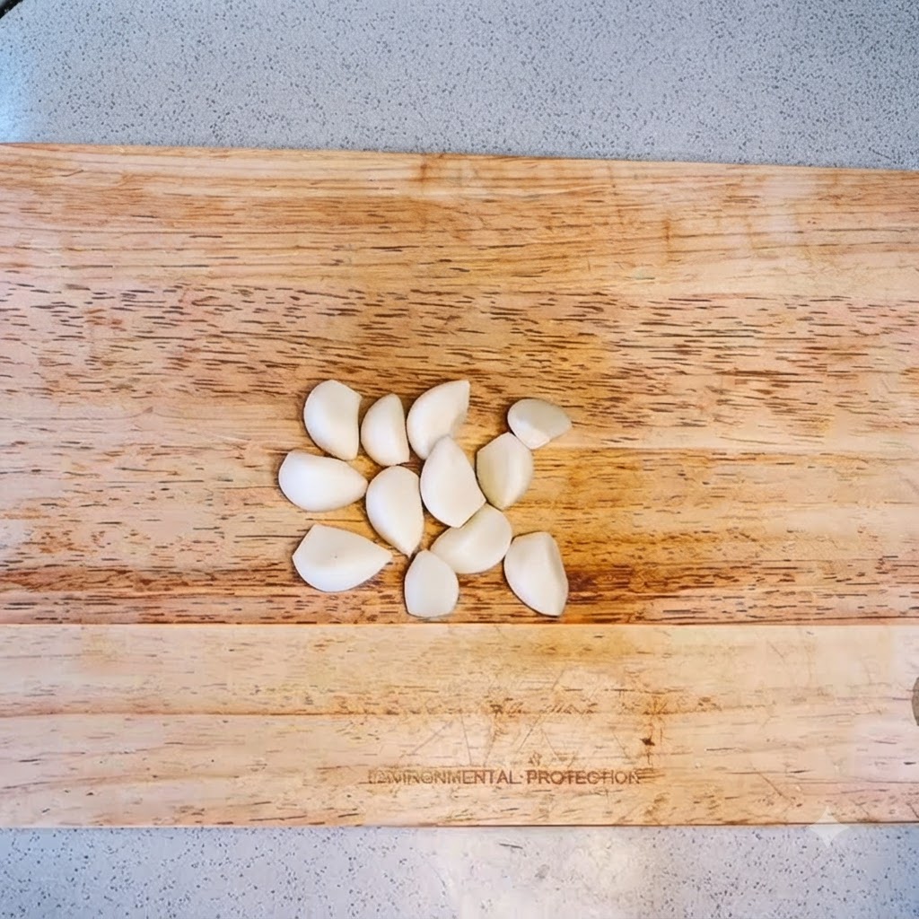 Dientes de ajo sobre una tabla de madera listos para ser picados.