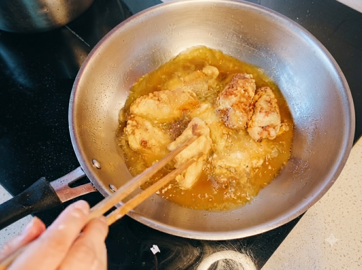 Alitas de pollo removidas y fritas por segunda vez en aceite muy caliente.