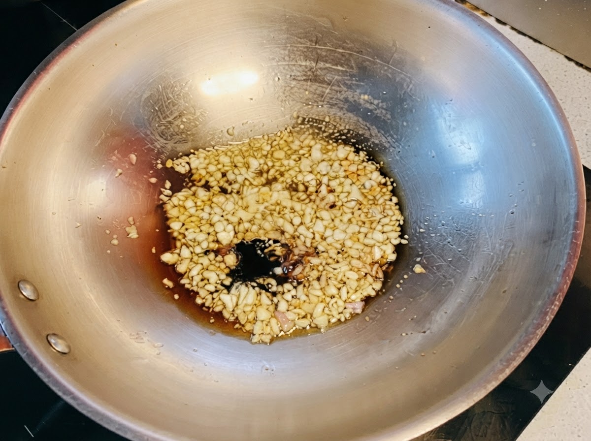 Salsas de soja oscura y clara combinadas con miel burbujeando sobre el ajo.
