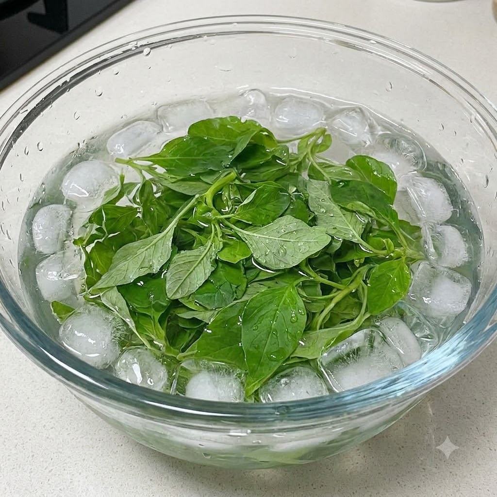 Hojas de albahaca fresca enfriándose en un bol lleno de agua con hielo.